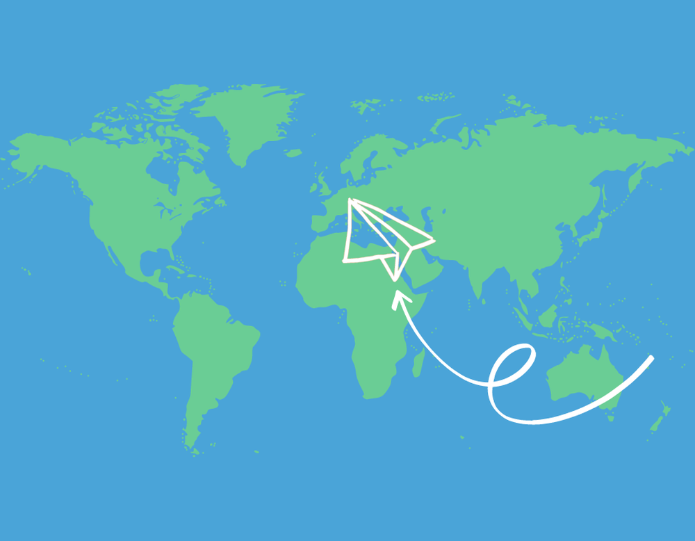 Weltkarte über die ein Papierflieger fliegt