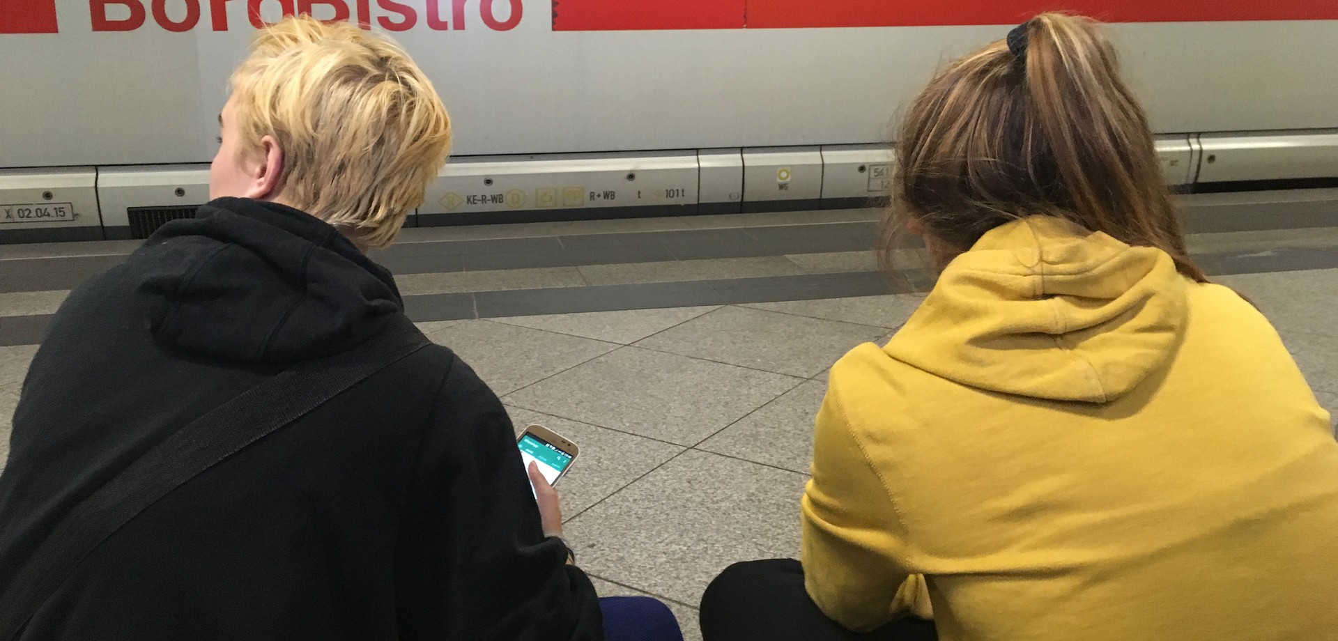 Foto von zwei Mädchen vor einem einfahrenden ICE